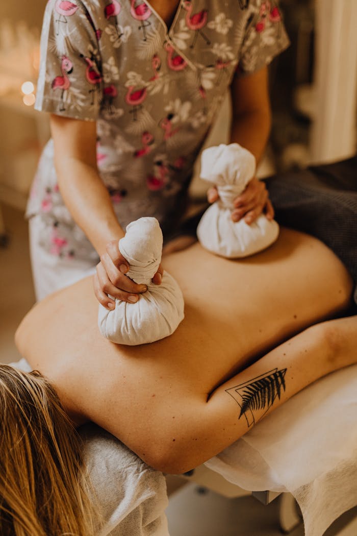 A soothing herbal compress massage for back pain relief, perfect for relaxation and wellness therapy.